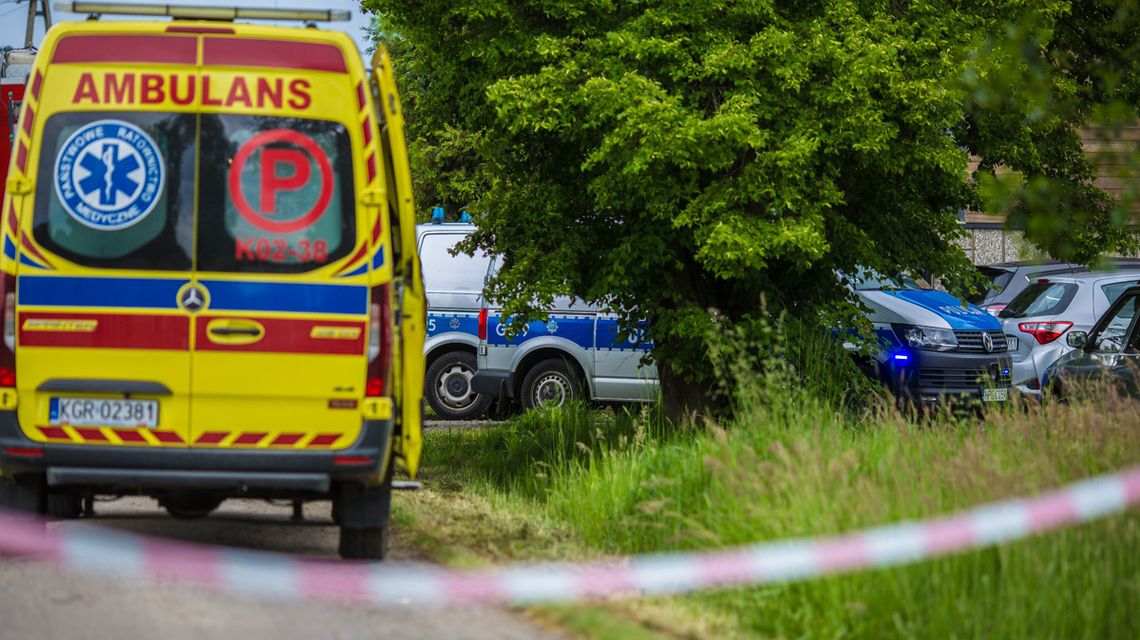 karetka i policyjne samochody w zaroślach przed domem