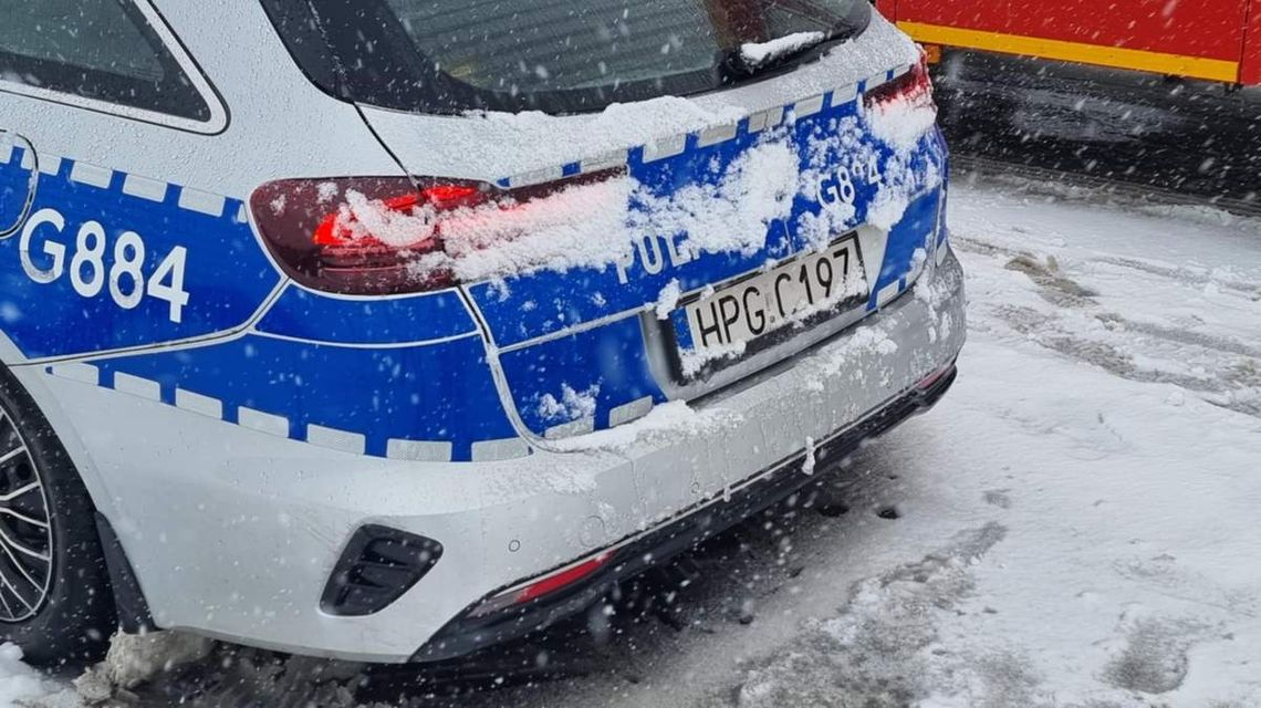zdjęcie przedstawia tył policyjnego radiowozu w śniegu