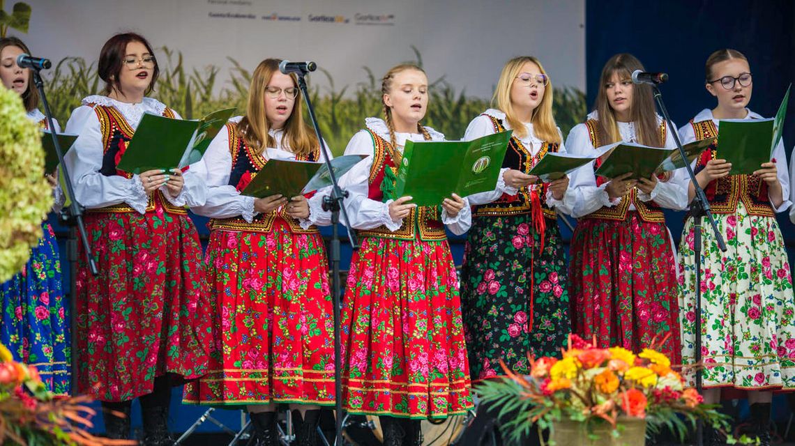 dziewczyny w ludowych strojach śpiewają na scenie