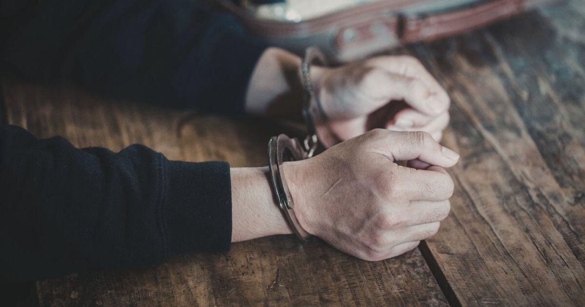 Zdjęcie przedstawia dłonie w kajdankach