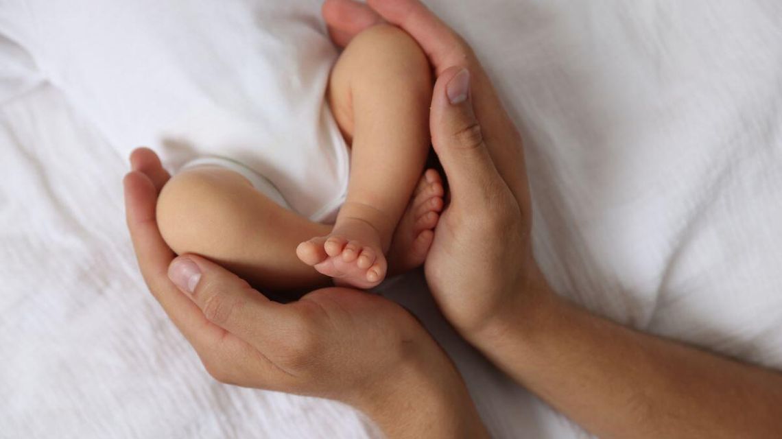 zdjęcie przedstawia dłoń obejmującą dziecko