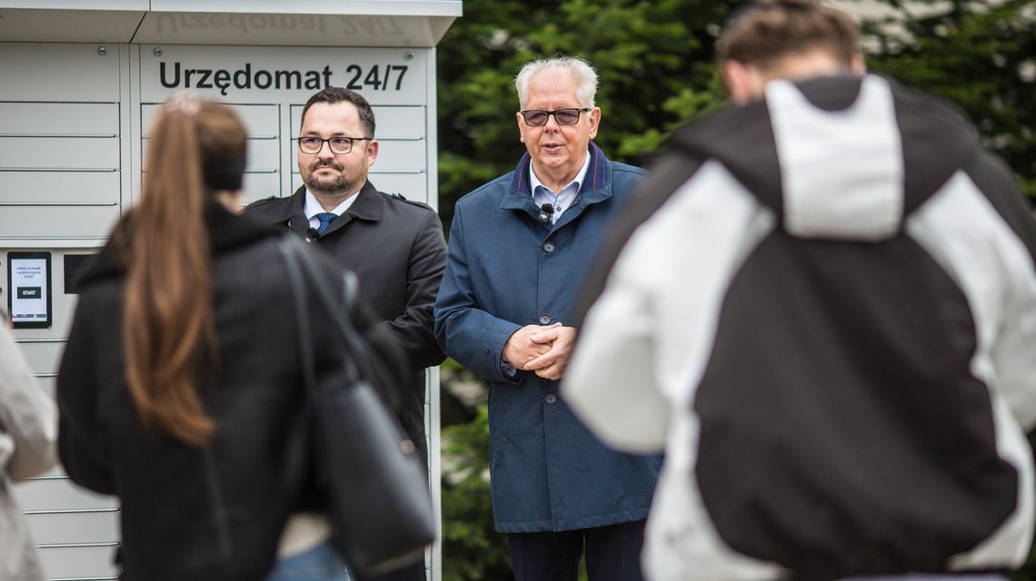 zdjęcie przedstawia dwóch mężczyzn przed urządzeniem w kształcie szafy na ulicy przed budynkiem w Gorlicach