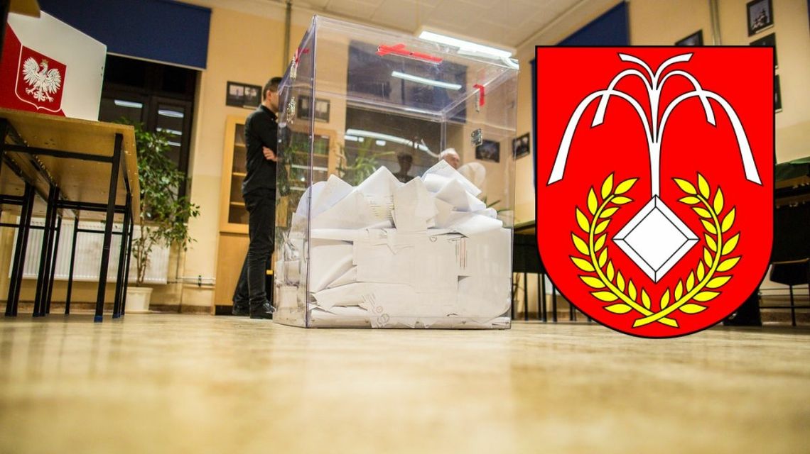 urna wyborcza w lokalu, na pierwszym planie grafika herbu gminy uście gorlickie