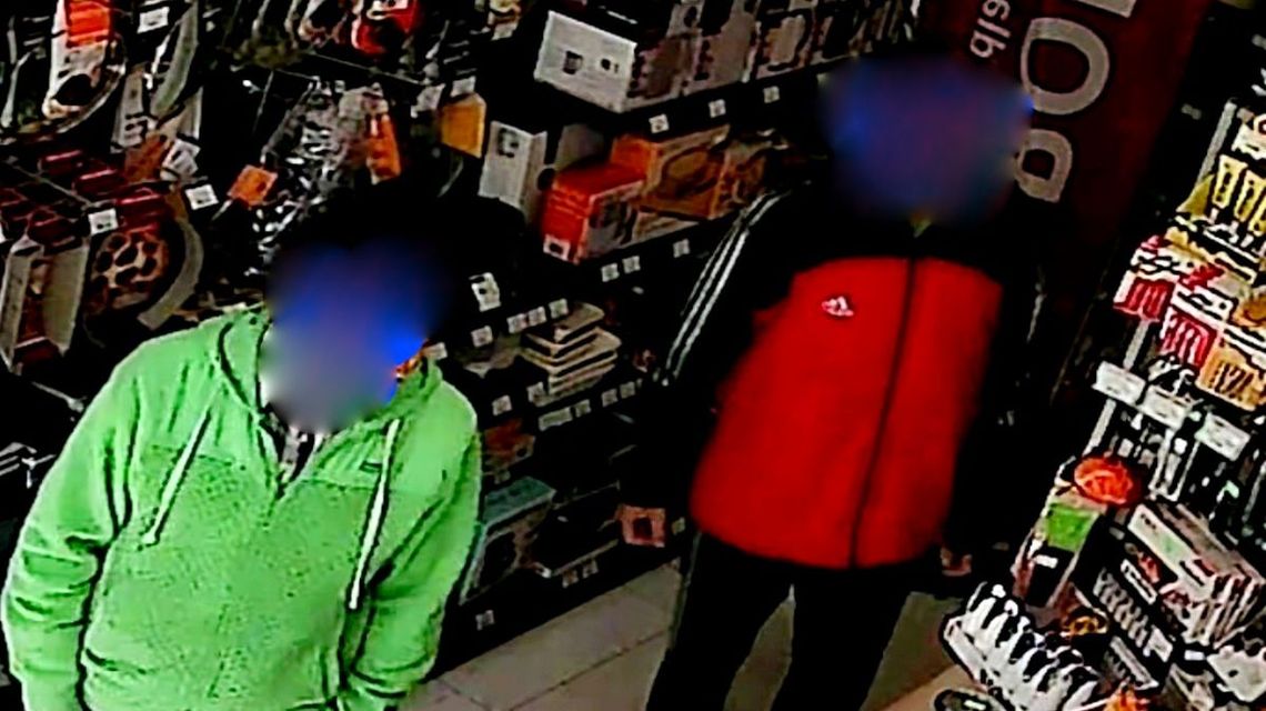 zdjęcie przedstawia dwóch mężczyzn między półkami w sklepie