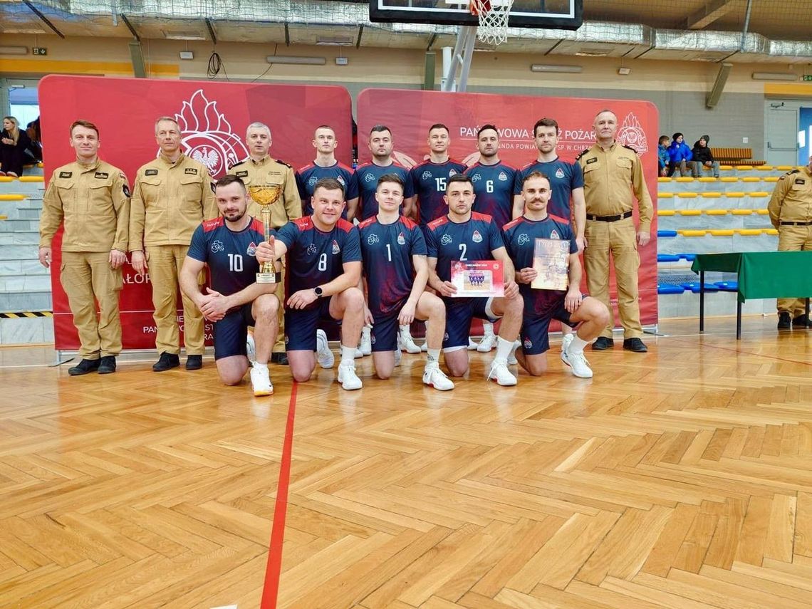 zdjęcie przedstawia grupę mężczyzn w strojach sportowych, obok mężczyźni w mundurach strażaków