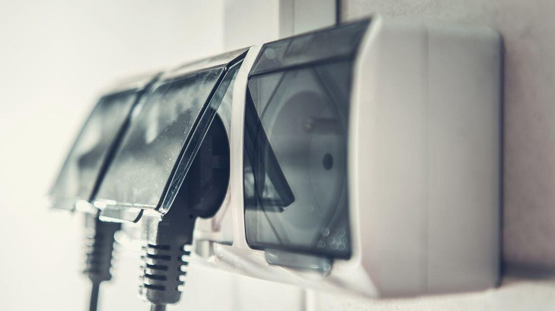 zdjęcie przedstawia gniazdko elektryczne i wpięte do niego wtyczki