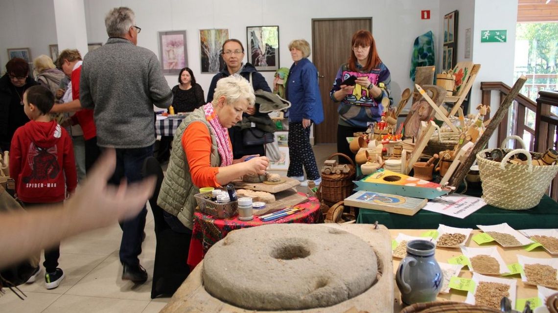 kilka osób chodzących między stanowiskami, gdzie sprzedawane jest rękodzieło