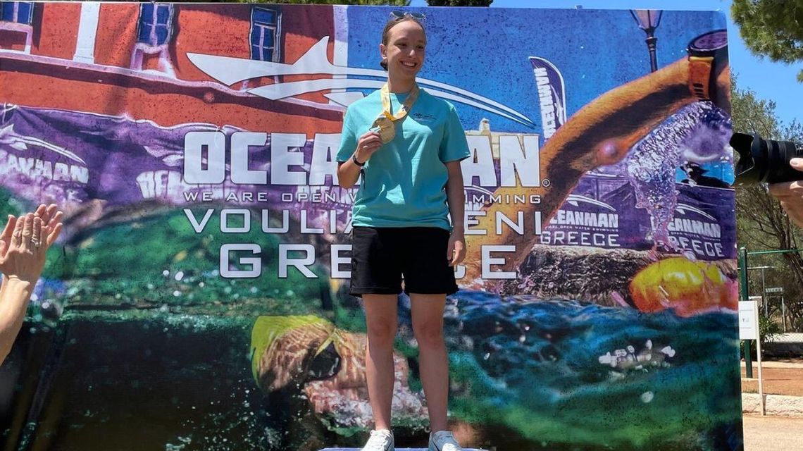 Zdjęcie dziewczyny na najwyższym stopniu podium.