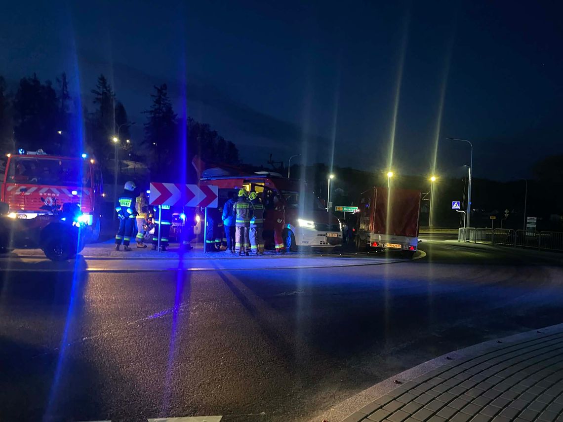 zdjęcie przedstawia wozy straży pożarnej i strażaków na jezdni w nocy