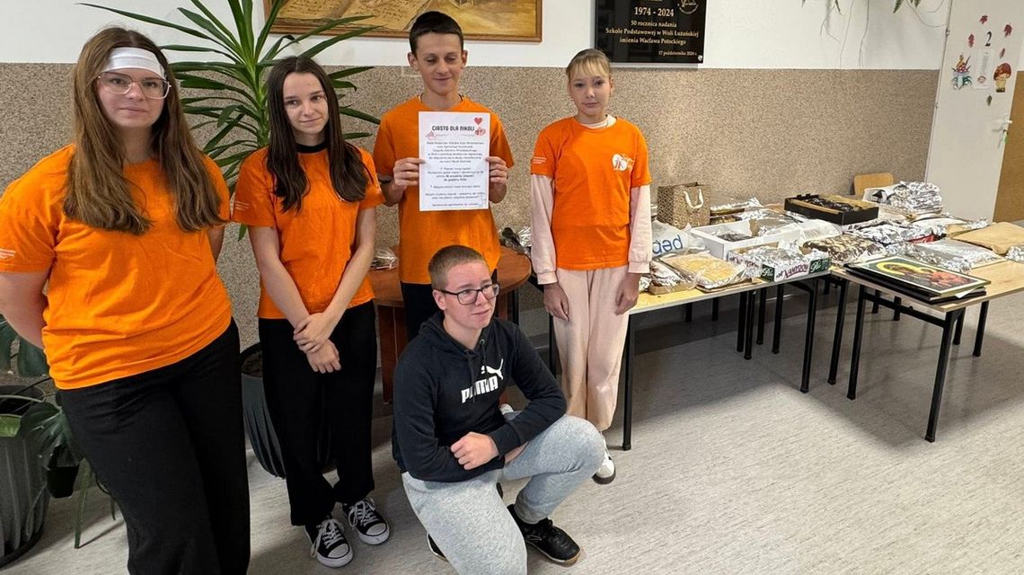 Wolontariat? Tylko z sercem! Szkolne Kluby Wolontariatu z powiatu gorlickiego świętowały Światowy Dzień Serca zdjęcie przedstawia dzieci w pomarańczowych koszulkach