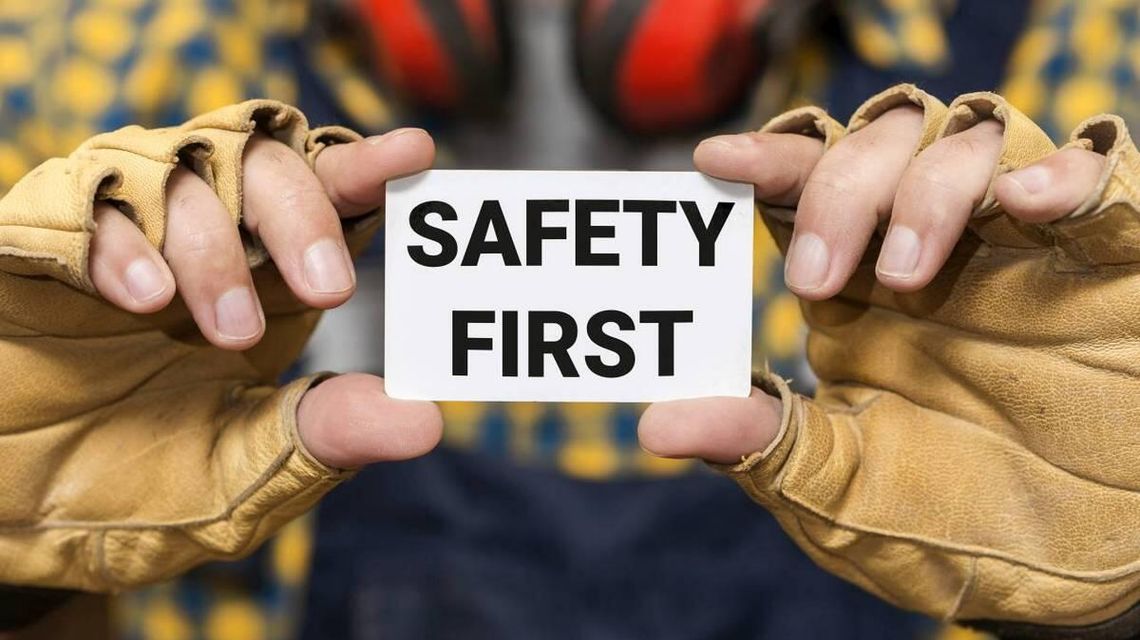 zdjęcie przedstawia ręcę, które trzymają kartkę z napisem SAFETY FIRST