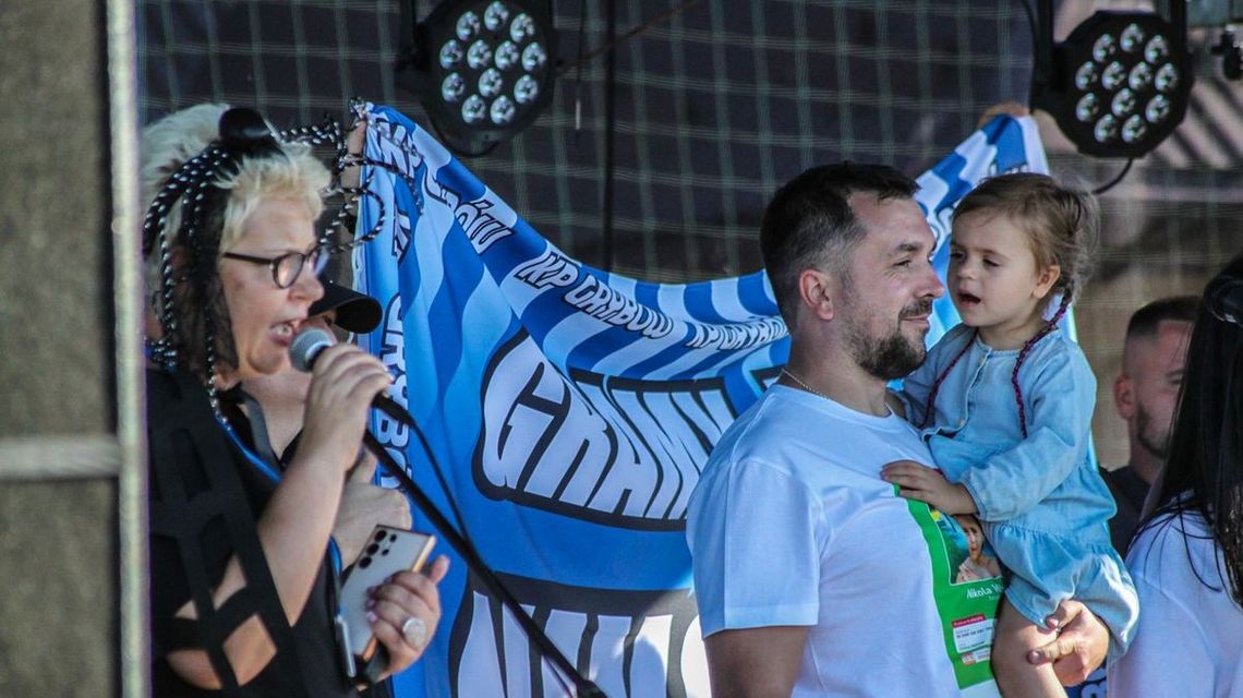 zdjęcie przedstawia dziewczynkę (Nikola Woźniak) na rękach mężczyzny podczas pikniku w Sękowej