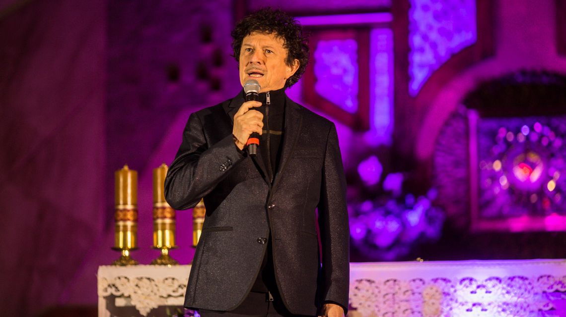 zdjęcie przedstawia mężczyznę z mikrofonem w kościele