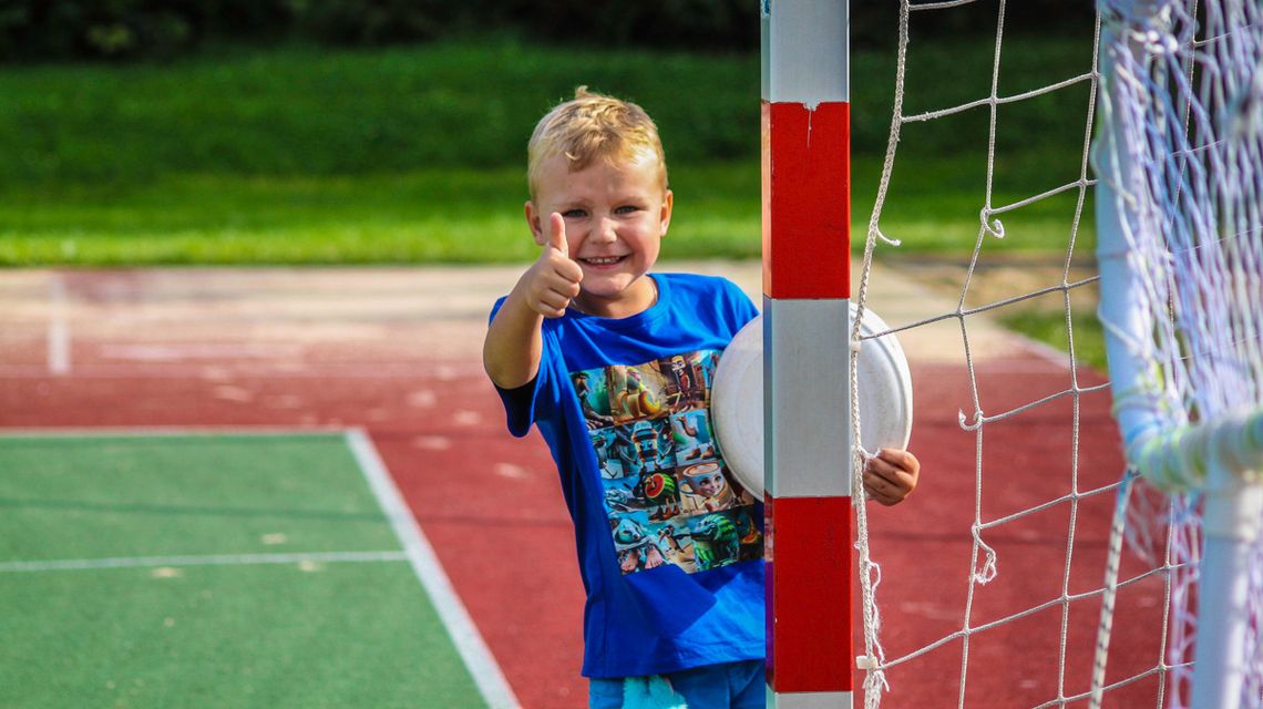 zdjęcie przedstawia chłopca, który pokazuje kciuk w górę