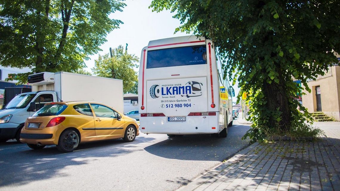 tył autobusu który jedzie ulicą obok inne pojazdy