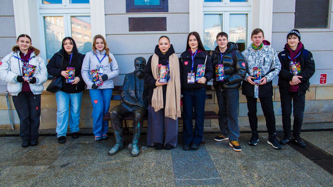 zdjęcie przedstawia grupę osób z puszkami przed budynkiem