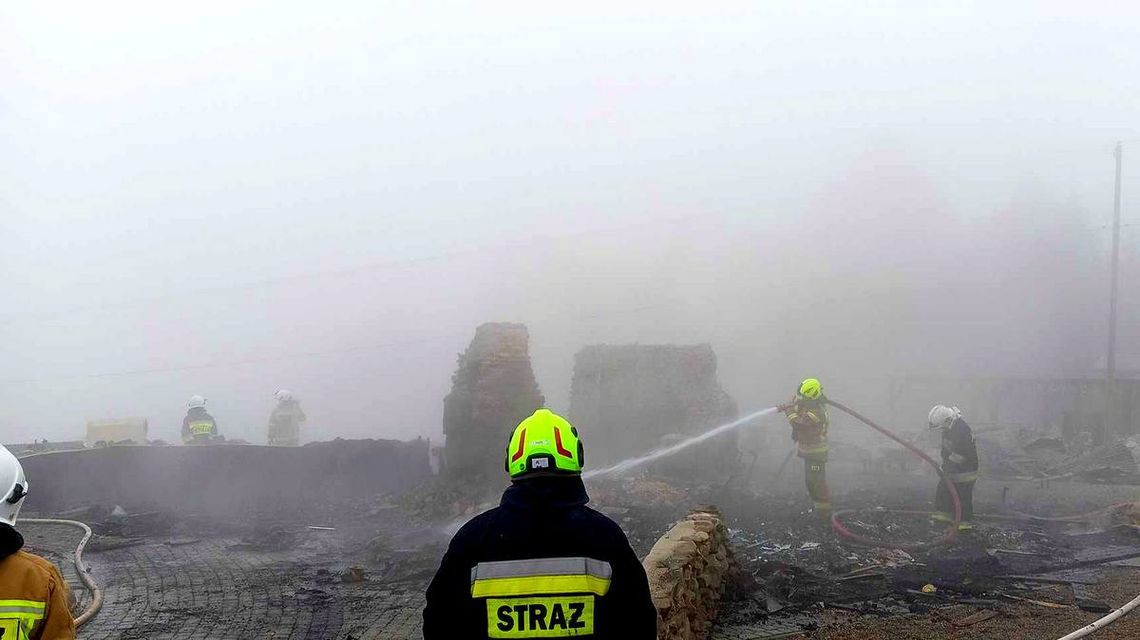 pogorzelisko po pożarze, na pierwszym planie strażak