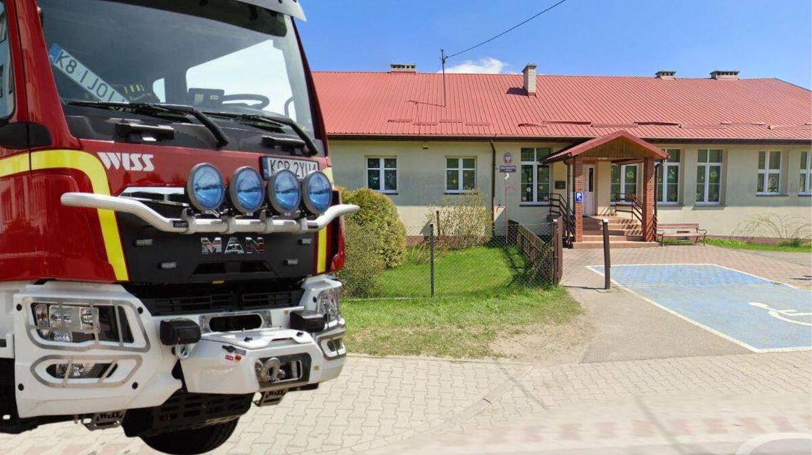 zdjęcie przedstawia samochód straży pożarnej przed budynkiem