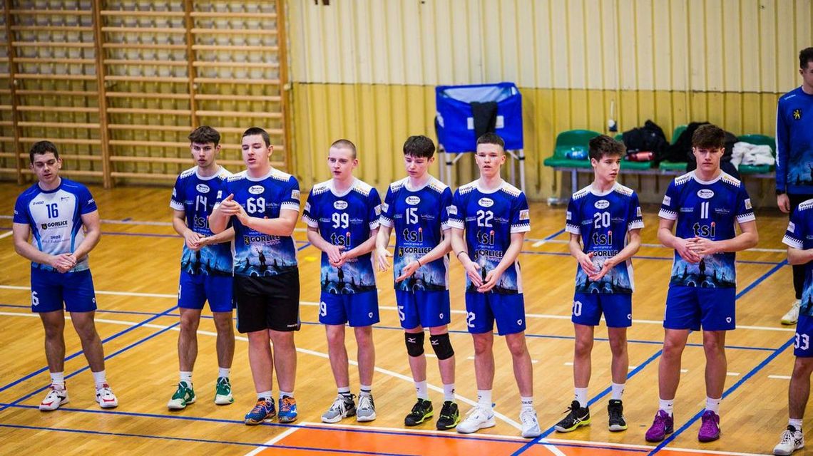 zdjęcie przedstawia chłopców stojących w rzędzie w koszulkach sportowych w hali sportowej