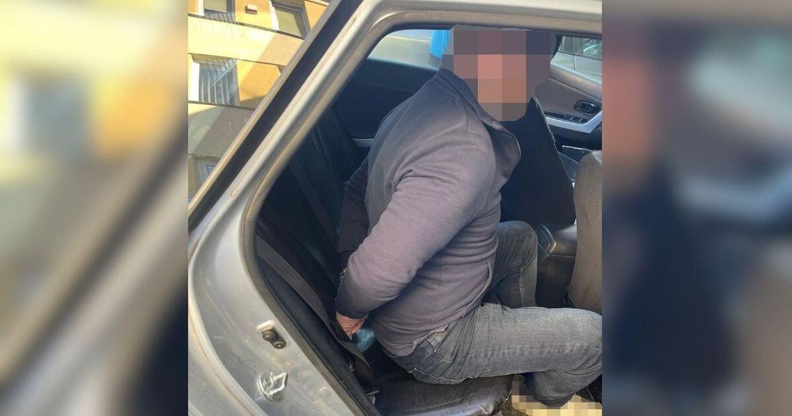 Policjanci zatrzymali poszukiwanego mężczyznę. Ścigała go niemiecka policja zdjęcie przedstawia zakutą w kajdanki osobę w samochodzie