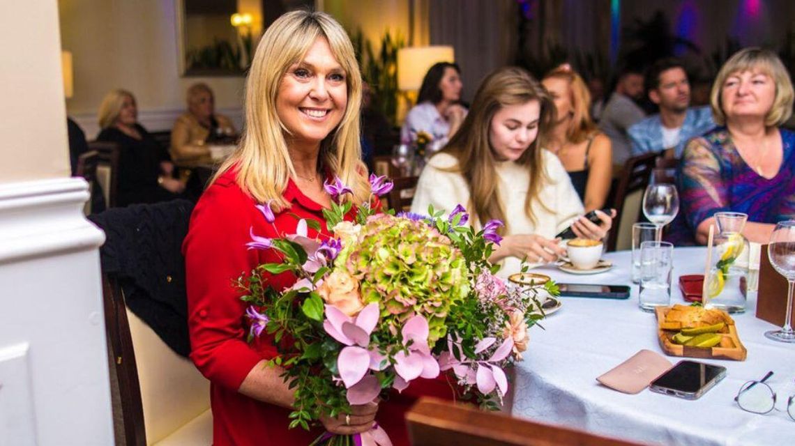 Zdjęcie przedstawia kobietę z kwiatami