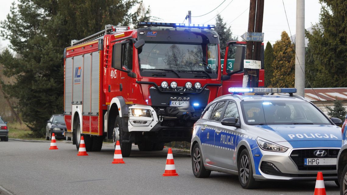 zdjęcie przedstawia policyjny radiowóz i wóz straży pożarnej