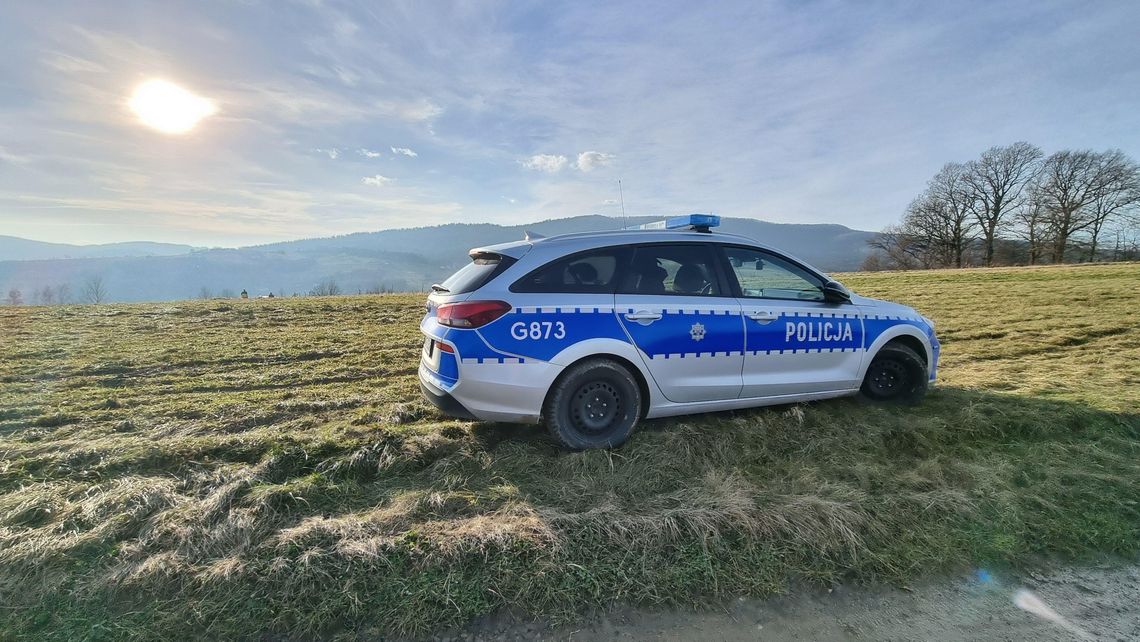 zdjęcie przedstawia policyjny radiowóz stojący w polu