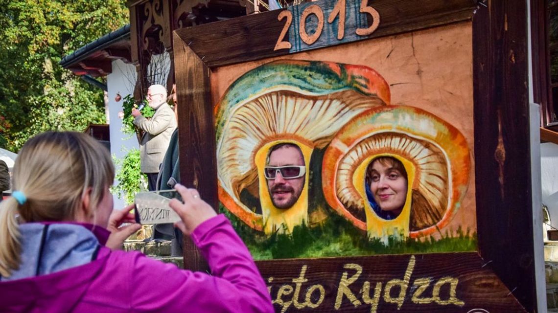 zdjęcie przedstawia osoby, które stoją za planszą w wyciętymi otworami na głowę