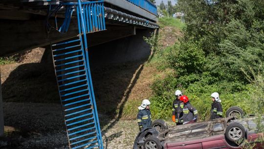 Siary. Samochód spadł z mostu na dach.