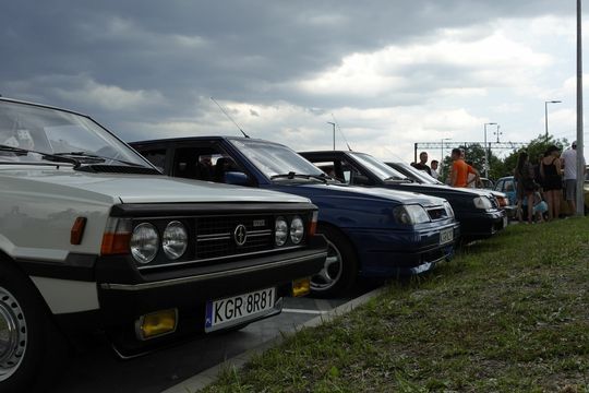 samochody i motocykle i ich kierowcy biorący udział w zlocie samochodowym