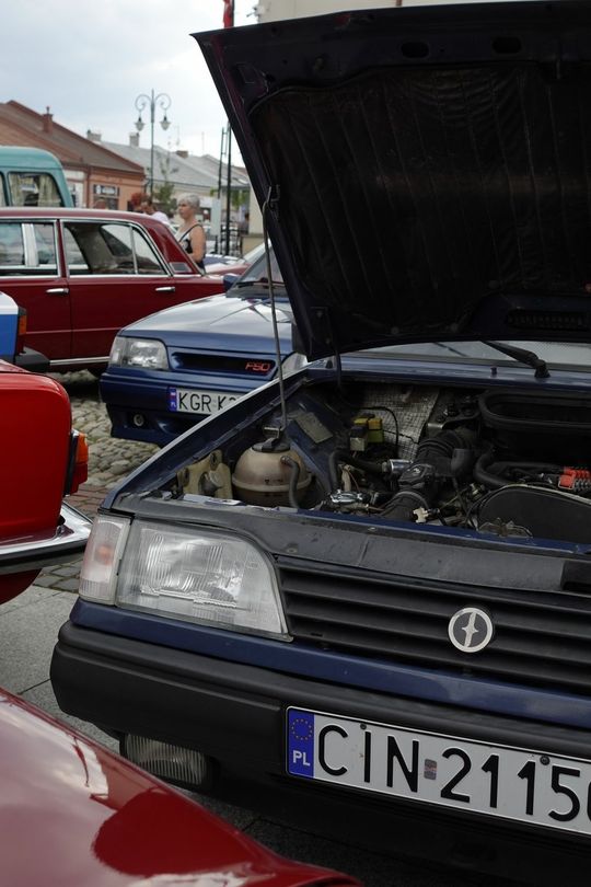 samochody i motocykle i ich kierowcy biorący udział w zlocie samochodowym