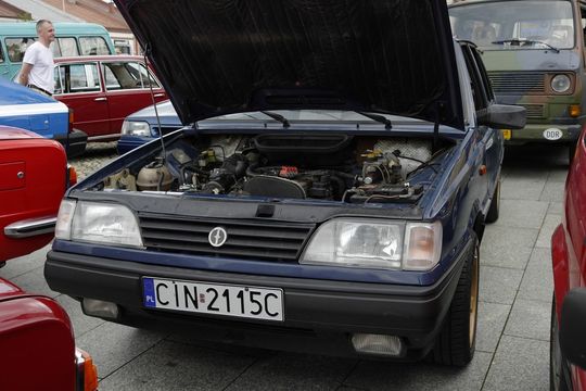 samochody i motocykle i ich kierowcy biorący udział w zlocie samochodowym