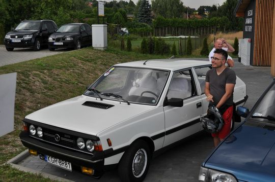 samochody i motocykle i ich kierowcy biorący udział w zlocie samochodowym