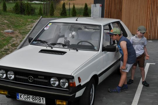 samochody i motocykle i ich kierowcy biorący udział w zlocie samochodowym