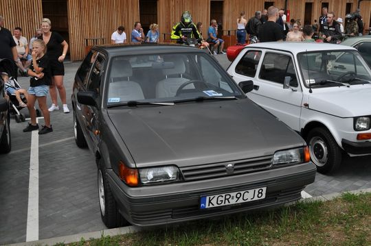 samochody i motocykle i ich kierowcy biorący udział w zlocie samochodowym