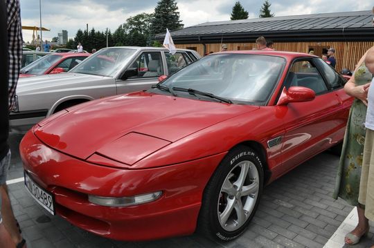 samochody i motocykle i ich kierowcy biorący udział w zlocie samochodowym