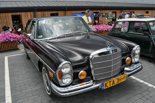 samochody i motocykle i ich kierowcy biorący udział w zlocie samochodowym