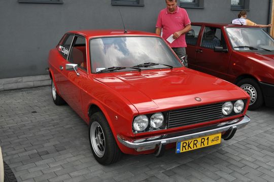 samochody i motocykle i ich kierowcy biorący udział w zlocie samochodowym