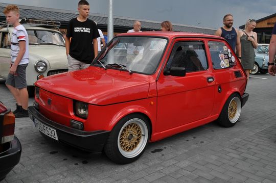 samochody i motocykle i ich kierowcy biorący udział w zlocie samochodowym