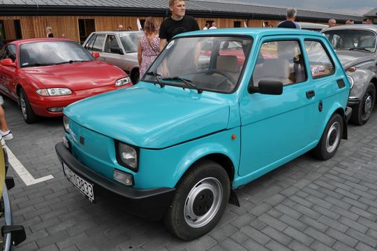 samochody i motocykle i ich kierowcy biorący udział w zlocie samochodowym