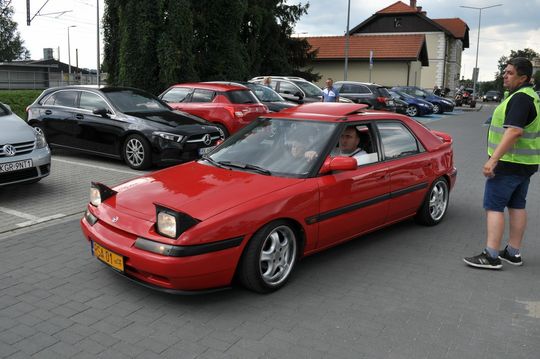 samochody i motocykle i ich kierowcy biorący udział w zlocie samochodowym