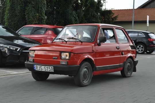 samochody i motocykle i ich kierowcy biorący udział w zlocie samochodowym