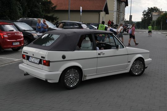 samochody i motocykle i ich kierowcy biorący udział w zlocie samochodowym