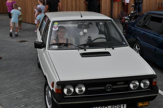 samochody i motocykle i ich kierowcy biorący udział w zlocie samochodowym