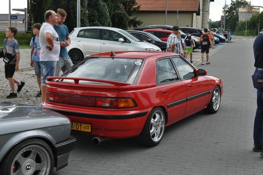 samochody i motocykle i ich kierowcy biorący udział w zlocie samochodowym