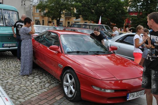 samochody i motocykle i ich kierowcy biorący udział w zlocie samochodowym