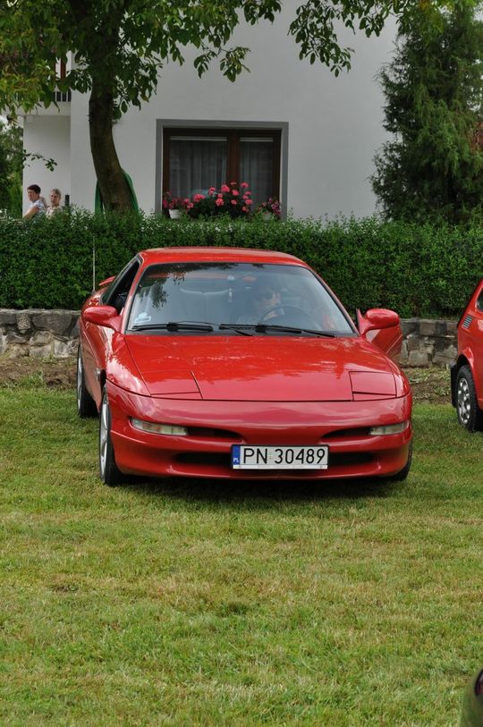 samochody i motocykle i ich kierowcy biorący udział w zlocie samochodowym