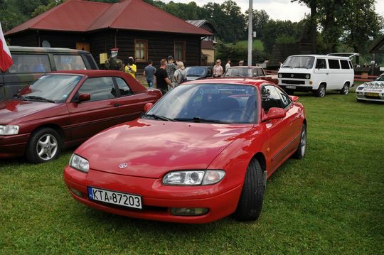 samochody i motocykle i ich kierowcy biorący udział w zlocie samochodowym