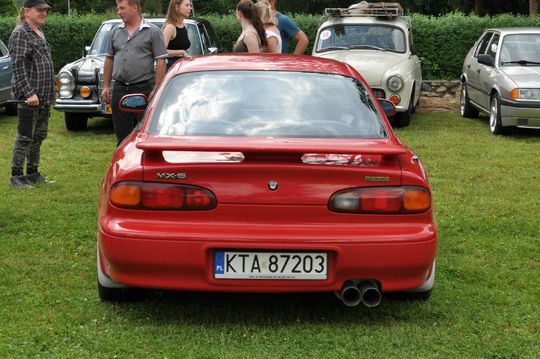 samochody i motocykle i ich kierowcy biorący udział w zlocie samochodowym