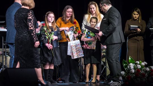 zdjęcie przedstawia grupę osób na scenie